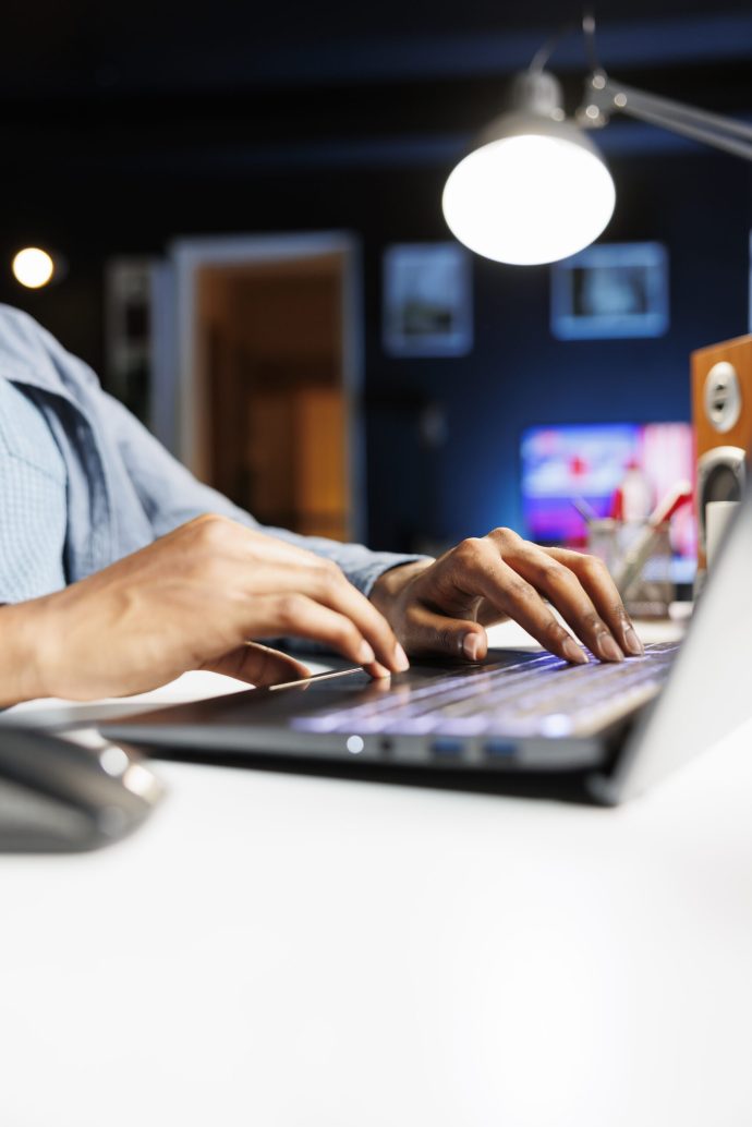 Remote tasks for company worker focusing on monthly earnings balance using legitimate financial details and web outputs. African american man manages his accounting tasks. Close up.